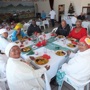 â€˜n Gesellige oomblik aan tafel tydens die NG Vrouediens se Uitreikaksie se jaarlikse Kersete aan die bejaardes van Silwerjare Dienssentrum